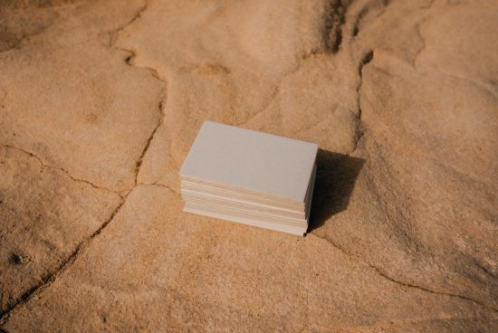 Stack of blank business cards on sandy surface for mockup design, ideal for brand presentation, print template display.